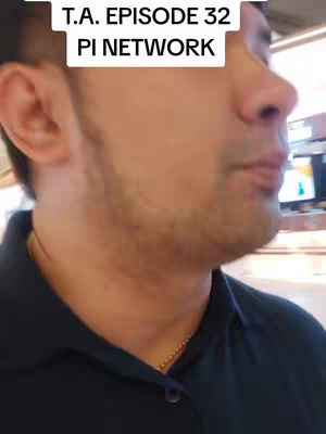 The cover image depicts a man from the chest up, facing slightly to the right. He has short hair, a trimmed beard, and is wearing a dark blue collared shirt with a small gold chain visible at his neck. Above him, a white rectangular box contains the text "T.A. EPISODE 32 PI NETWORK". The background details are slightly out of focus, suggesting a casual setting.