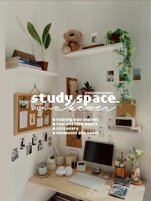 A well-lit photo showcases a cozy study space in the corner of a room. The walls are painted a soft white. A wooden desk, positioned in the corner, holds a computer monitor, keyboard, mouse, headphones, and stationery. Decorative elements include floating wall shelves holding books, a teddy bear, and plants, along with photos pinned to a corkboard. The overall composition is neat, organized, and aesthetically pleasing, with neutral tones and natural textures. Accent colors from the plants and books provide visual interest.