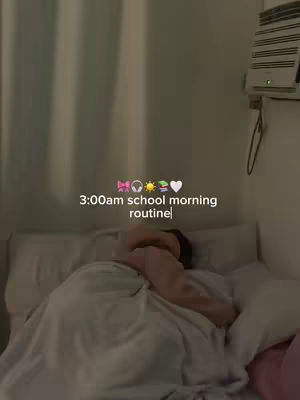 The cover image shows a dimly lit bedroom scene. A person is lying in bed, mostly covered by a white blanket. The text overlay at the center says "3:00am school morning routine". The lighting is soft and warm.