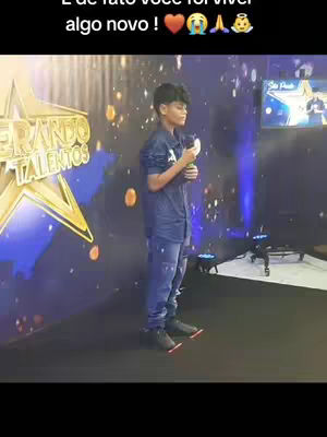 A young man stands on a stage with a microphone, a background with a star graphic, and the words 'Esperando Talentos' visible. The setting suggests a talent show.