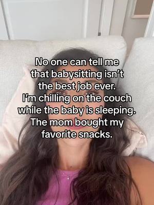 The cover image is a selfie-style shot of a young woman reclining comfortably on a bed or couch. She's facing the camera directly, with natural lighting illuminating her face and long, dark hair. Text is overlaid on the image, conveying a positive sentiment about babysitting.