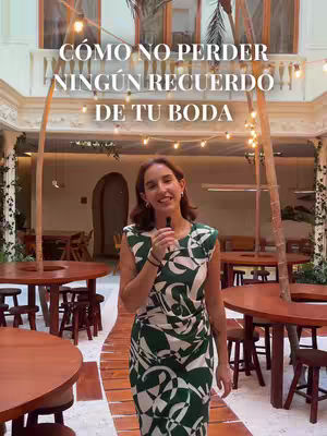 The cover image shows a woman standing in an indoor courtyard setting. She is wearing a green and white patterned dress and holding a microphone. The background includes wooden tables and chairs, archways, and decorative string lights. The text overlay reads: 'CÓMO NO PERDER NINGÚN RECUERDO DE TU BODA.'