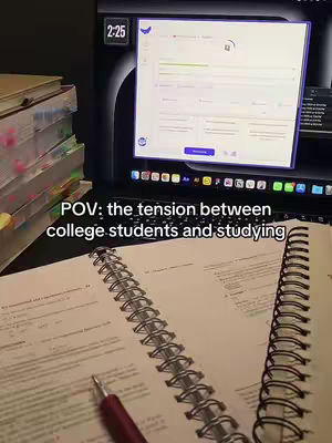 A workspace featuring a computer, open notebooks and a pen, with text overlayed. The computer displays a user interface in the background, with a stack of books with post-it notes to the left. The foreground shows an open notebook and a pen.