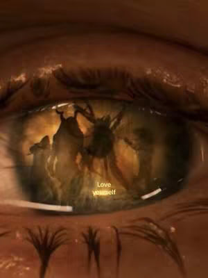 Close-up of an eye with a blurred background. Reflected in the eye is a brown and orange scene, possibly depicting an illustration. The text overlay 'Love yourself' is in yellow.