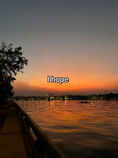 A serene sunset view over a river with buildings in the distance and the text overlayed with the context I hope.