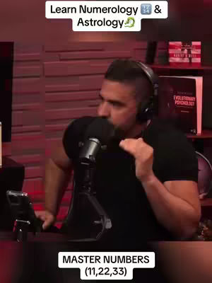 A man with short dark hair and a beard is speaking into a microphone. He is wearing a black t-shirt and headphones. The background is dark, with some shelves holding books and other items. Text overlays on the top and bottom of the image.