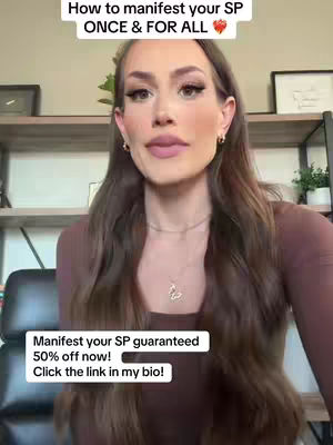 A woman with long brown hair and makeup is centered in the frame. The image is brightly lit, and the background is slightly blurred, featuring shelves and a plant and a framed picture. Text overlays are present, indicating the video's content.