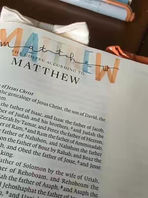The cover image shows a Bible open to the beginning of the Gospel of Matthew, with the book title customized with colored text overlays. The word "Matthew" is highlighted in orange, while the "THE GOSPEL ACCORDING TO" and the first letter of this word is in the color blue and the first letter of the word "Matthew" has a sky blue color, which gives a visual appeal. On the white pages of the Bible, there is text that can be seen, but not be interpreted in detail.