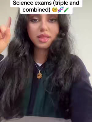 A young woman with long, wavy dark hair holds up one finger while looking directly at the camera. Over her head, a text overlay reads "Science exams (triple and combined)" with science-related emojis.