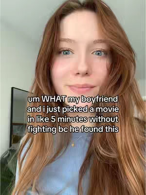 A selfie-style shot featuring a young woman with long auburn hair. She looks directly at the camera with a slight smile, her blue eyes visible. She is wearing a light blue long-sleeve shirt . The background is blurred, suggesting a domestic setting. Overlay text at the bottom provides context about the content.