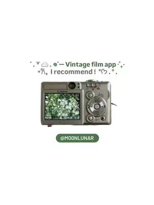 The cover image features a silver vintage digital camera, positioned centrally against a white background. The camera screen displays a blurred green image, possibly foliage, suggesting the subject of a photo. Above the camera, are small decorative elements, and text that reads "Vintage Film App. I recommend! °♡°. " is overlaid. Below the camera is a green banner with the username @MOONLUNAR. The overall aesthetic is clean and minimalist with a touch of vintage charm.