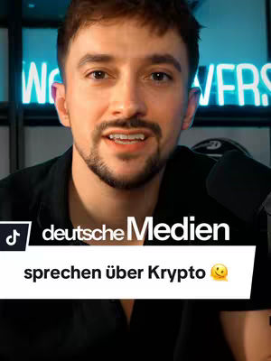 A medium shot of a man with short dark hair and a beard, facing the camera with a neutral expression. The background has blurry lights, with a neon sign that says 'VERS'. A text overlay at the bottom reads 'deutsche Medien sprechen über Krypto' and a smiling face emoji. The overall composition suggests a video about cryptocurrency in the German media.