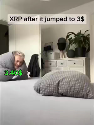 A person wrapped in a blanket sits on a bed with a pillow in the foreground. Text overlays read 'XRP after it jumped to 3$' and '3.40$'. The scene is brightly lit, with a neutral color palette enhancing the focus on the text and subject.