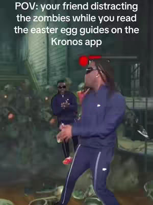 A man in a blue tracksuit is dancing with his back to the camera while another man is in the background, both in a green lit background. The foreground text says "POV: your friend distracting the zombies while you read the easter egg guides on the Kronos app".