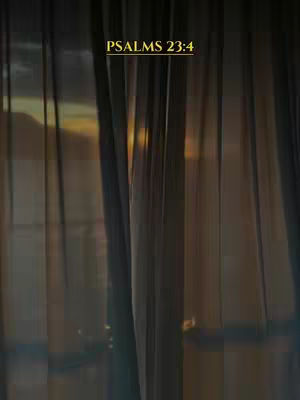 The image features translucent curtains in the foreground, with vertical lines creating a layered effect. Behind the curtains, a blurred view of a sunset or sunrise is visible, with warm, golden light. The overall composition is soft and muted, creating a sense of peace and tranquility. Text overlayed at the top says 'PSALMS 23:4'.