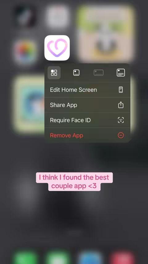 The image is a screenshot of a phone's home screen displaying app icons, with a menu overlay offering options like "Edit Home Screen". The focus is on an app icon with a purple heart, suggesting a relationship or love theme. A pink text overlay at the bottom reads "I think I found the best couple app <3".