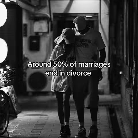 A black and white photograph shows a man and a woman walking arm in arm down an alley. The woman is on the left wearing an oversized striped shirt and holding a cap. The man is on the right, wearing a t-shirt and baseball cap. Text is overlaid on the image.
