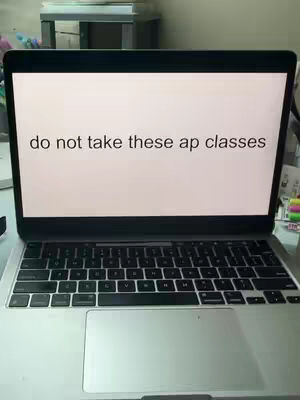 A laptop displaying the text 'do not take these ap classes'. The laptop is open on a desk with other items in the background.