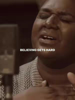 A medium shot shows a woman with dark skin, facing slightly to the side with her mouth open. The text overlayed on the image reads, 'BELIEVING GETS HARD' in white font.