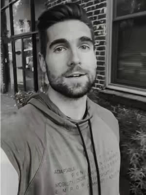 The cover image is a black and white selfie of a man in a hoodie. He is in front of a brick wall and a window. He has a beard and short hair. His expression is pleasant and engaged. The hoodie appears to have text printed on it.