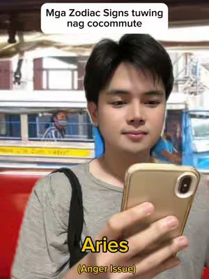 A young man is holding a phone, staring at the screen with a neutral expression, set against a blurred background that includes a bus and partial view of other people. Text overlays label it as a zodiac sign with an associated trait