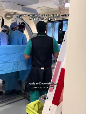 The cover image shows a scene inside what appears to be an operating room. A person in the foreground, viewed from the back, is wearing green scrubs, a black vest, and a surgical cap. They are facing toward a monitor displaying medical imagery. Behind them, other people are partially visible, also in surgical attire. The room is brightly lit, with medical equipment and instruments in view.