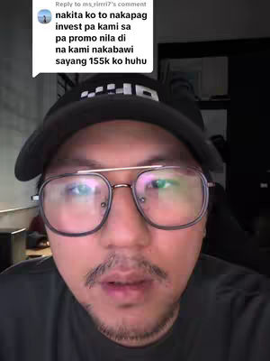 A close-up shot of a man's face from the chest up. He's wearing a black hat and eyeglasses. A text overlay is visible in a speech bubble.