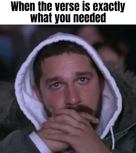 A man wearing a white hooded sweatshirt is the focus, with his hands covering his mouth and a pensive expression. The background is blurred, suggesting a crowded setting. Text overlayed at the top reads 'When the verse is exactly what you needed'.