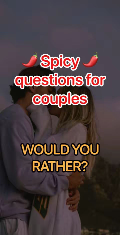 A cover image featuring a couple embracing in front of a dark, moody background. Text overlays highlight the video's theme, including "Spicy questions for couples" and "Would You Rather?" arranged in a visually engaging design. The image uses a warm color palette with red and yellow accents for the hook text to draw attention.