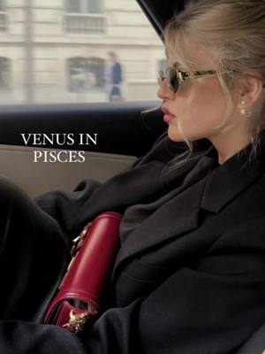 The cover image shows a woman in the back seat of a car. She's wearing sunglasses and red lipstick, with her blonde hair pulled back. The image has a warm, slightly desaturated color palette. The text 'Venus in Pisces' is overlaid at the bottom left.