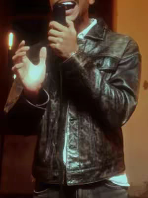 The cover image features a man holding a microphone with an open mouth. He wears a leather jacket over a white shirt. The background is blurred and warm toned with soft lighting.