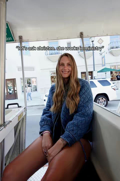 A woman with long blonde hair sits in a passenger seat, smiling at the camera. Text overlay on the image reads, '"let's ask christen. she works in ministry"'. The background is blurred, showing a street scene.