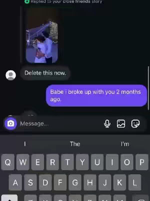 The image shows a smartphone messaging interface against a black background. At the top, a small video clip is embedded in a bubble, displaying a couple. Below this, a text bubble contains the message: "Babe i broke up with you 2 months ago." A keyboard with the letters and symbols is displayed at the bottom of the image.