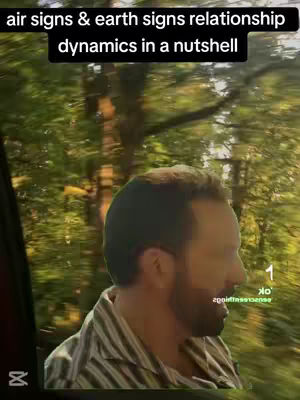 A man with a beard is seen in a car, driving through an area with trees. Text overlays state "air signs & earth signs relationship dynamics in a nutshell".