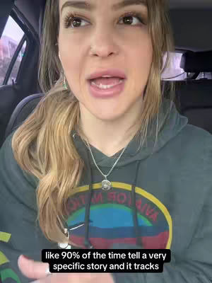 A woman sitting in a car, turned towards the camera with a serious facial expression. She wears a dark green hoodie with a colorful logo and a silver necklace. Text overlayed on the bottom of the screen reads: "like 90% of the time tell a very specific story and it tracks". The background is blurry, with a window and a peek of the outside environment.