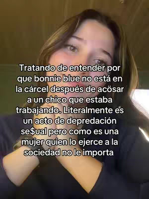A selfie-style video cover image featuring a young woman with brown hair in a dark-colored top. She appears to be inside, as the background is slightly out of focus, and the lighting suggests indoor conditions. Text is overlaid on the image, conveying a message related to another individual and social perception.