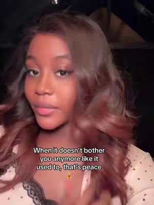 A woman with long, wavy, brown hair is centered against a dark background. She is looking towards the camera with a slightly pouting expression. The overlaid text states the peace in not being bothered by things that used to bother you.
