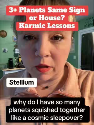 A selfie-style video cover image of a woman looking directly at the camera. She has fair skin, dark eye makeup, and red lipstick. Above her head are two rectangular text overlays. The top one reads "3+ Planets Same Sign or House?" in white font on a red background. Below it, also on a red background, "Karmic Lessons" is written in white text. A smaller white rectangular overlay near the bottom of the image reads "Stellium". Black text on the bottom is within a black rounded rectangle which reads "why do I have so many planets squished together like a cosmic sleepover?"