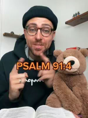 A man wearing glasses, a black beanie, and a black hoodie is speaking with a teddy bear. Text overlay 'PSALM 91:4' is displayed in an orange font.