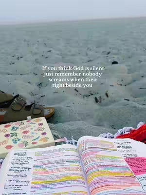 The photo shows a sandy beach scene. In the foreground lies an open bible with colorful highlights, a floral journal, and sandals. The background is a soft blend of sea and sky, with text overlaying the image.