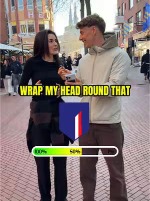 A photo featuring two individuals standing next to each other with a city backdrop. A woman on the left with dark hair is holding a phone and speaking to a man on the right. Bright colored text overlays the image, along with a progress bar and a badge.