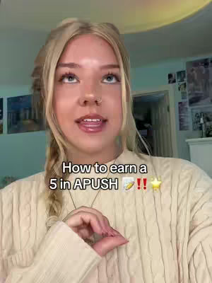 A young woman with blonde hair styled in a braid is centered in the frame, smiling towards the camera. Text overlays the image. The background includes a glimpse of a room with decorative art, suggesting a home setting.