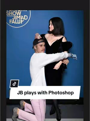 The image shows Justin Bieber posing with Selena Gomez. Justin kneels and embraces Selena from behind, who stands in a black dress, hands on his shoulders. A text box at the bottom reads 'JB plays with Photoshop'. The background is a solid blue.