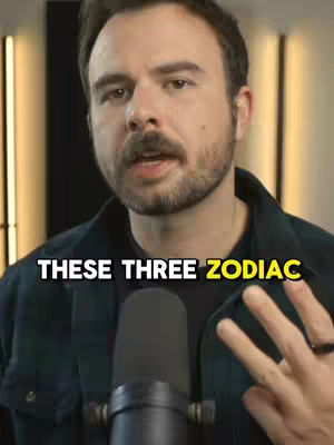 A man with dark hair and a beard is centered in the frame behind a microphone. Text overlayed on the bottom of the image reads "THESE THREE ZODIAC." The man is holding up three fingers on his right hand..