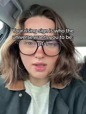 The cover image shows a woman with short brown hair, wearing large black-rimmed glasses, and a black jacket. Text overlayed on the image reads, 'Your rising sign is who the universe wants you to be: pt. 1'. The woman is looking towards the camera, and the background suggests she is sitting in a car.