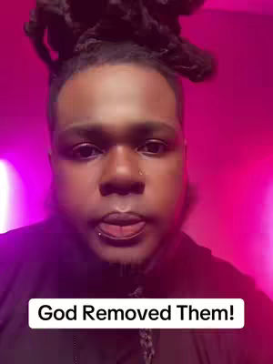A man with locs, a beard, and a nose ring is centered. The background is a gradient of pink and purple. A text overlay at the bottom says "God Removed Them!"