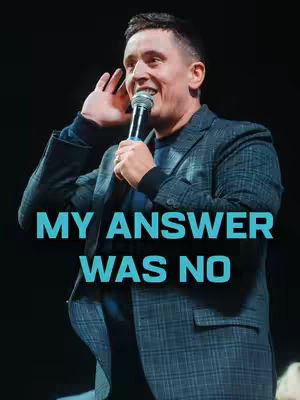 A man in a dark suit jacket holding a microphone, looking towards the left, with the text overlayed in the center, 'MY ANSWER WAS NO.'