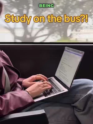 The cover image shows a person sitting on a bus, typing on a laptop. The person is wearing a maroon jacket and jeans. Through the window, a blurred green tree and the sky are visible. Text overlays read 'BEING' and 'Study on the bus?!'.