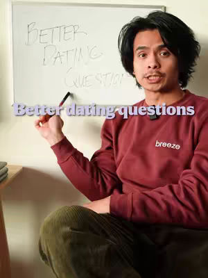 The cover image shows a man seated, holding a pen, with a whiteboard behind him. The whiteboard has handwritten text that reads, "BETTER DATING QUESTIONS". Above the man's head, there is a text overlay "Better dating questions". He is wearing a red sweater with the word "breeze" visible. The man is of Asian descent, and his expression suggests he is addressing the camera.