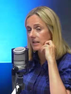 The cover image shows a woman with blonde hair holding a microphone. She's wearing a blue and black plaid shirt and has a subtle ring on her finger. The background appears to be a gradient of blues and greys. She is looking off to the left side of the image, touching her face with her right hand.